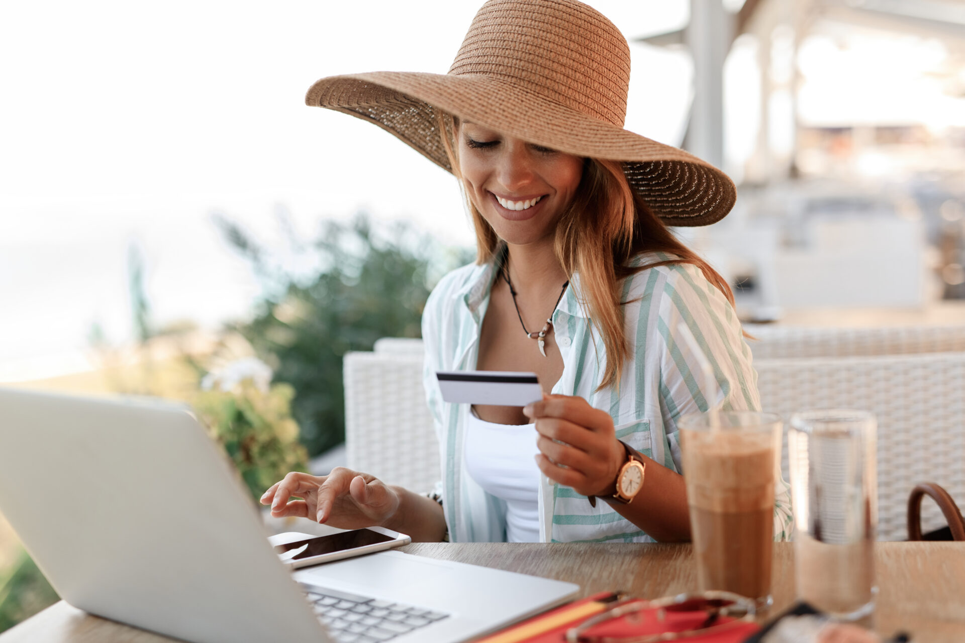 jeune femme souriante tenant une carte de crédit pour achat en ligne - Communication digitale médecines douces